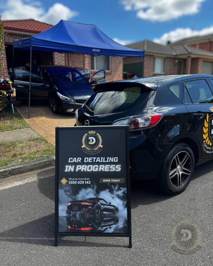 Detailing Dream Squad mobile car detailing setup with canopy and signage in front of customer home in Sydney showing car detailing in progress