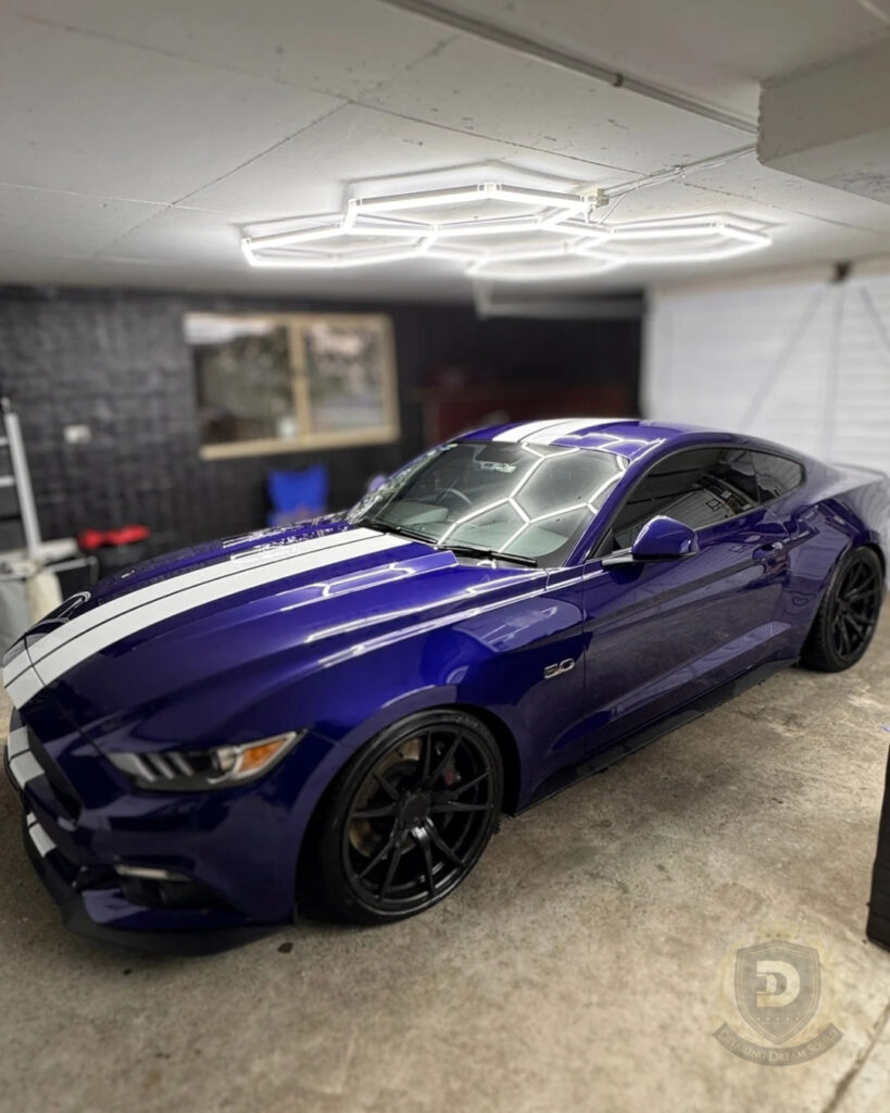 Blue Ford Mustang 5.0 with white racing stripes showing high gloss paint and sharp reflections after professional detailing and paint correction at Detailing Dream Squad in Sydney