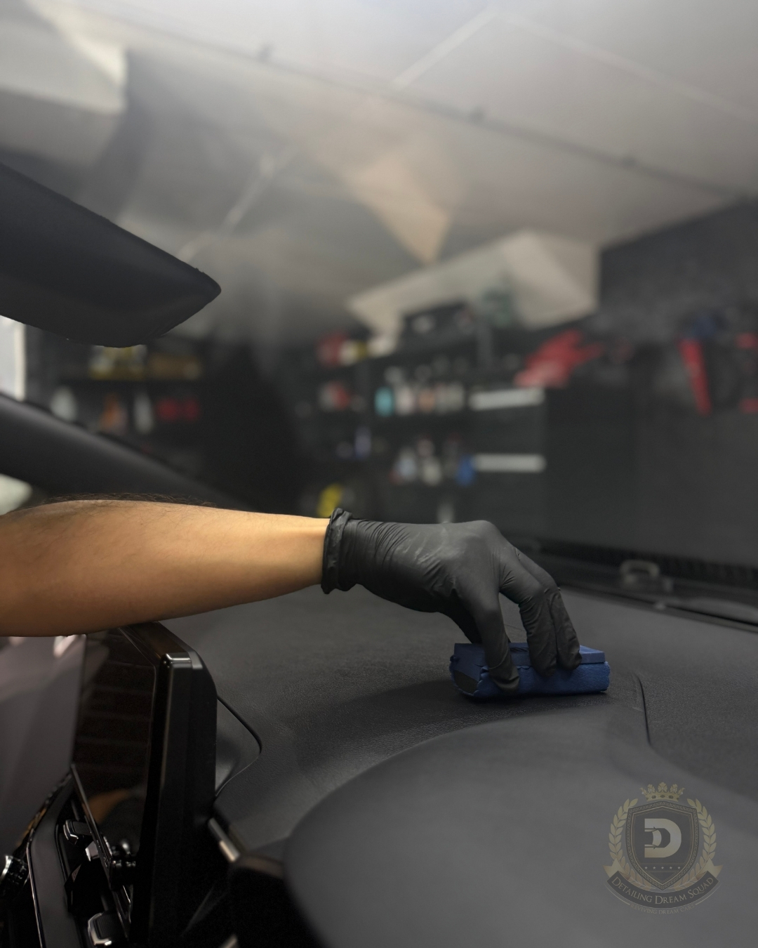 Detailing technician applying interior ceramic coating to car dashboard at Detailing Dream Squad