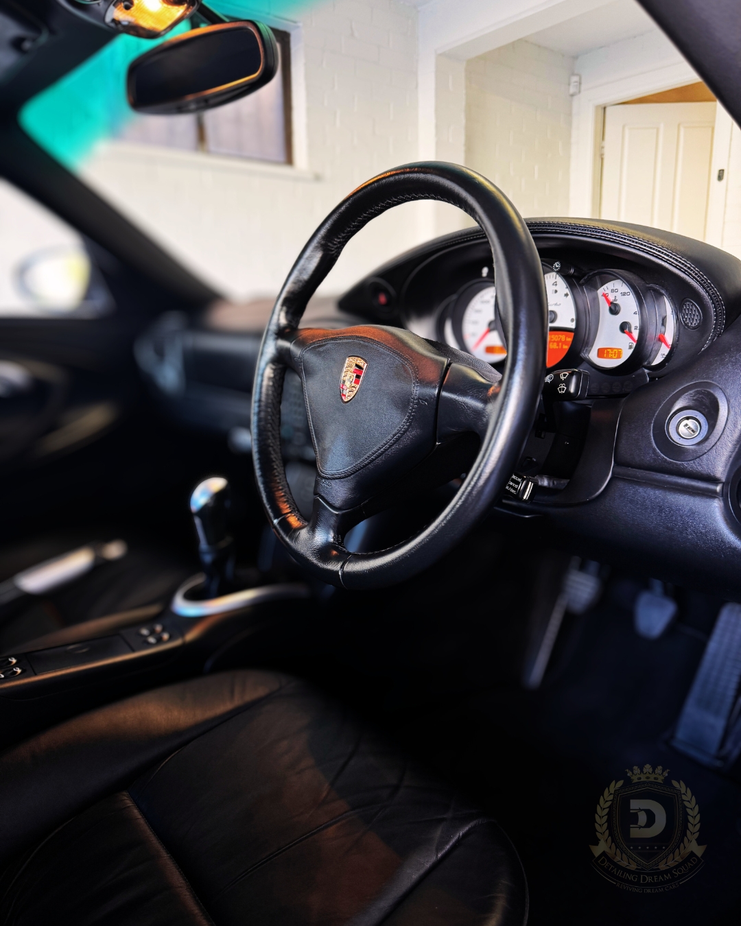 Detailed Porsche interior showing clean leather steering wheel and dashboard after professional detailing by Detailing Dream Squad in Sydney.